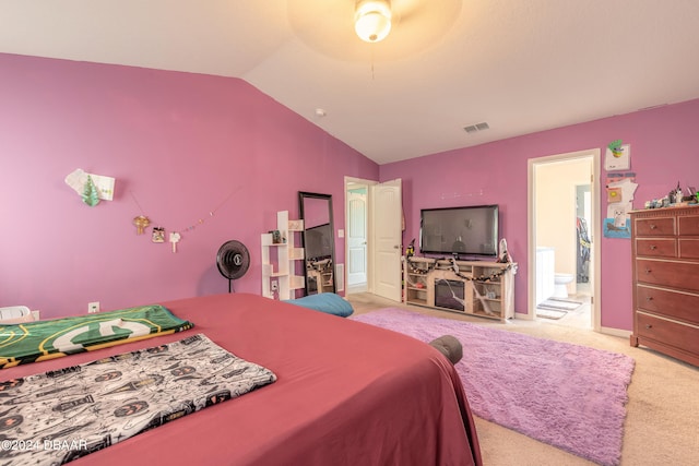 carpeted bedroom featuring connected bathroom and vaulted ceiling