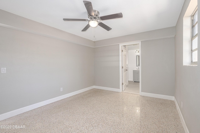 284 Military Blvd, Ormond Beach, FL 32174 - empty room with dark aggregate flooring, a ceiling fan, and baseboards