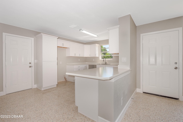 kitchen with white cabinets, sink, and kitchen peninsula