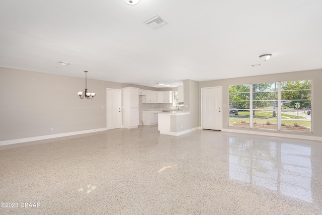 unfurnished living room featuring an inviting chandelier