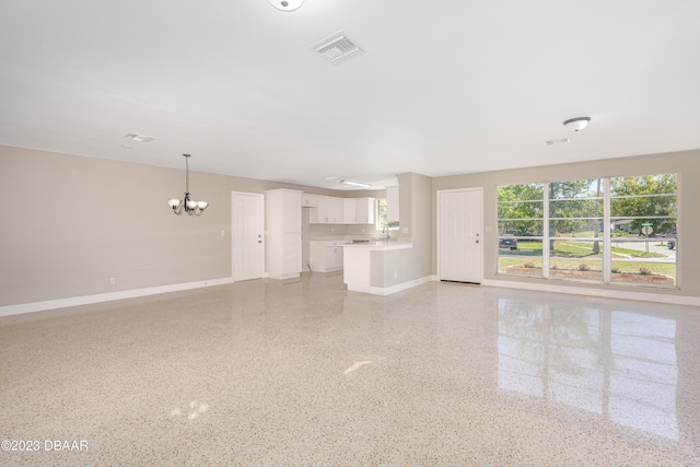 284 Military Blvd, Ormond Beach, FL 32174 - unfurnished living room featuring a chandelier, baseboards, and dark speckled floor