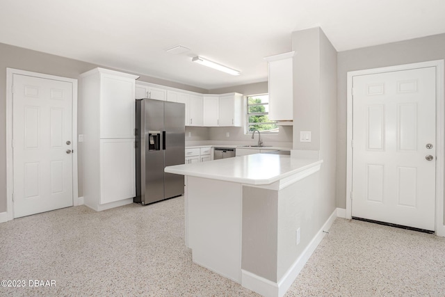 kitchen with white cabinetry, kitchen peninsula, appliances with stainless steel finishes, and sink