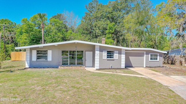 284 Military Blvd, Ormond Beach, FL 32174 - mid-century modern home featuring stucco siding, an attached garage, driveway, and a chimney