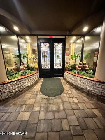 view of exterior entry with french doors and a patio area