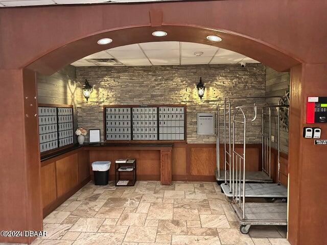 interior space featuring a mail area and wooden walls