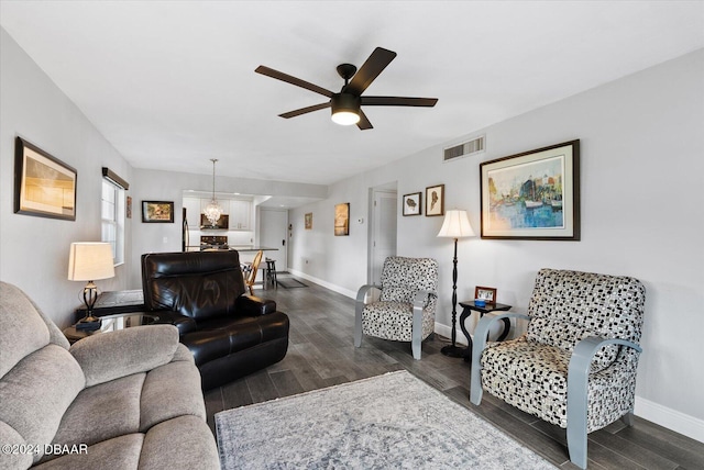 living room with ceiling fan and dark wood-type flooring