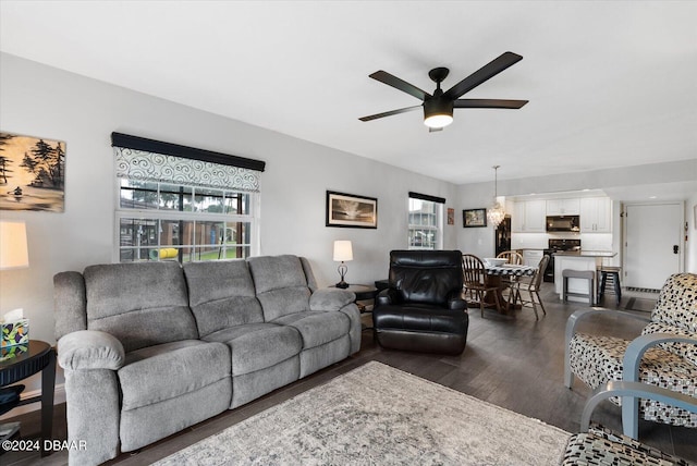 living room featuring ceiling fan, a healthy amount of sunlight, and dark hardwood / wood-style floors