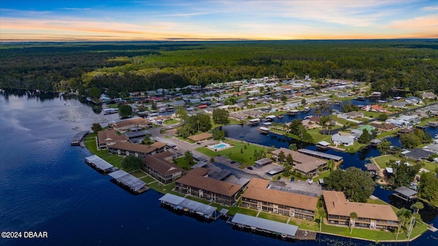 aerial view at dusk featuring a water view