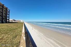 view of home's community featuring a water view and a beach view