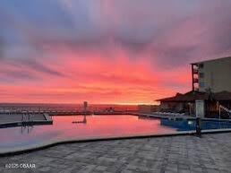 pool at dusk featuring a water view