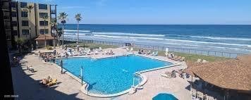 view of pool featuring a water view and a patio area