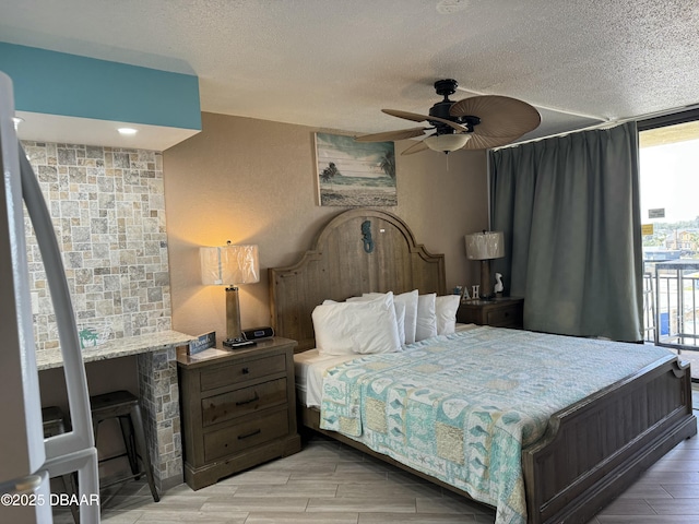 bedroom featuring expansive windows, ceiling fan, and a textured ceiling