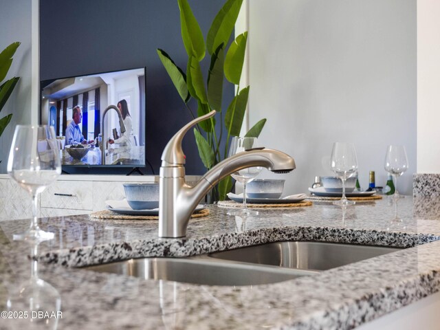 interior details with stone countertops and sink