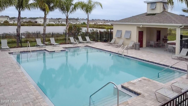 view of pool featuring a water view and a patio area