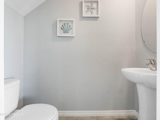 bathroom with vaulted ceiling, sink, and toilet