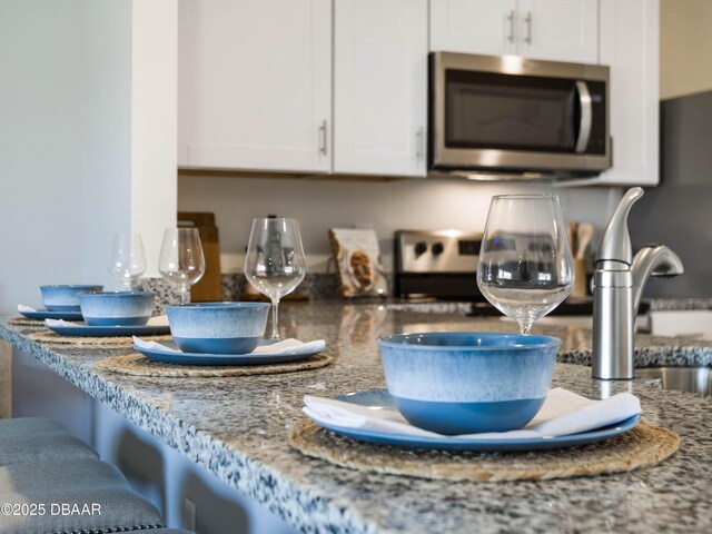 kitchen featuring stone counters and white cabinets