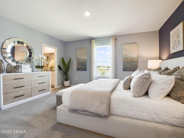 bedroom featuring ensuite bathroom and carpet flooring