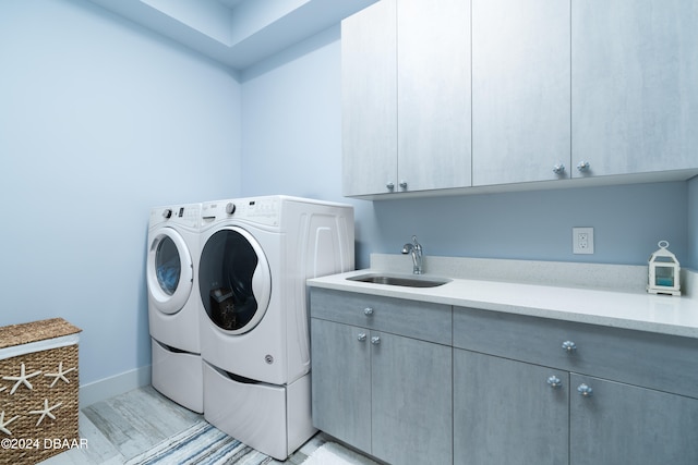 laundry room with cabinets, sink, and washer and dryer