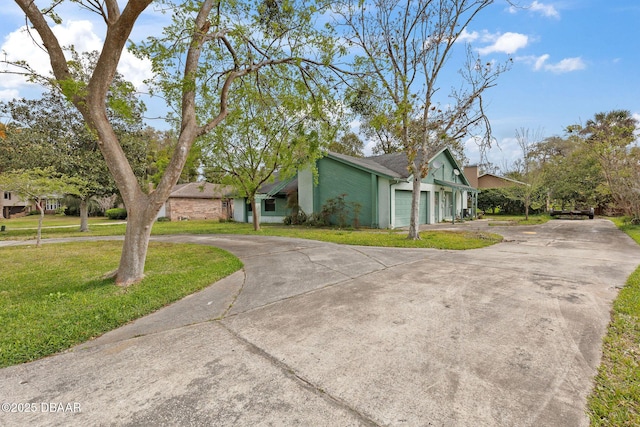 view of front of house featuring an attached garage, driveway, and a front yard