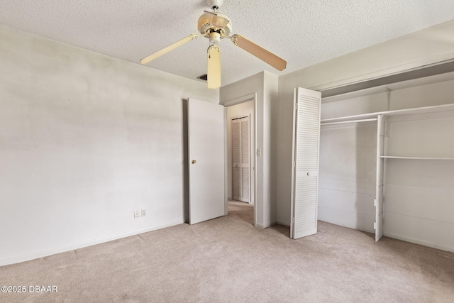 unfurnished bedroom featuring a closet, carpet flooring, ceiling fan, and a textured ceiling