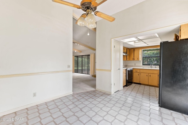 kitchen with range with electric cooktop, a sink, light countertops, freestanding refrigerator, and light floors