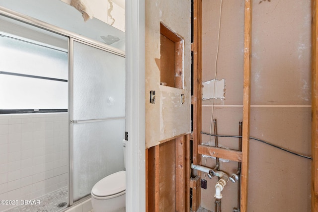 full bathroom featuring a stall shower and toilet