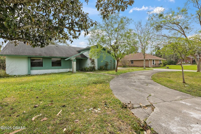 view of front of property with a shingled roof, a front yard, and driveway