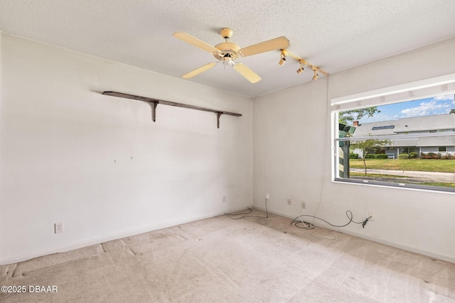 empty room with carpet, ceiling fan, a textured ceiling, and baseboards