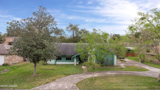 view of front of property featuring driveway, a shingled roof, and a front yard