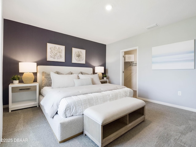 bedroom featuring a walk in closet and carpet