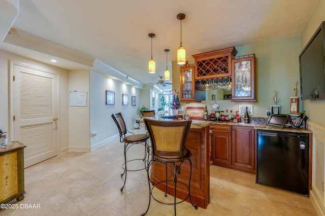 bar featuring crown molding, decorative light fixtures, refrigerator, ceiling fan, and light stone countertops