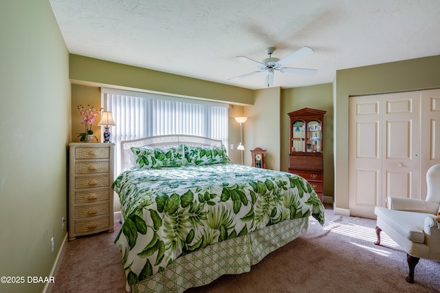 carpeted bedroom with ceiling fan, a closet, and a textured ceiling