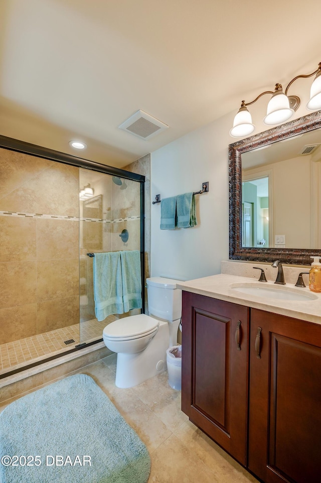 bathroom featuring vanity, toilet, tile patterned flooring, and a shower with door