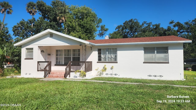 ranch-style home featuring a front yard and covered porch