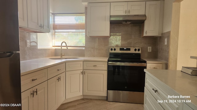 kitchen with white cabinetry, sink, tasteful backsplash, fridge, and electric range