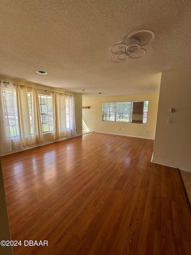 unfurnished room featuring hardwood / wood-style floors and a textured ceiling