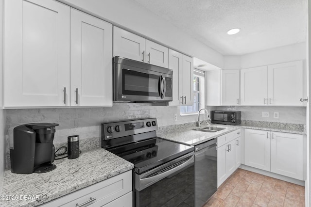 321 Scotland Dr, Holly Hill, FL 32117 - kitchen with stainless steel appliances, a sink, white cabinetry, and a textured ceiling