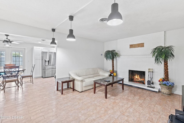 321 Scotland Dr, Holly Hill, FL 32117 - living room featuring a ceiling fan, a fireplace, and light wood-style flooring