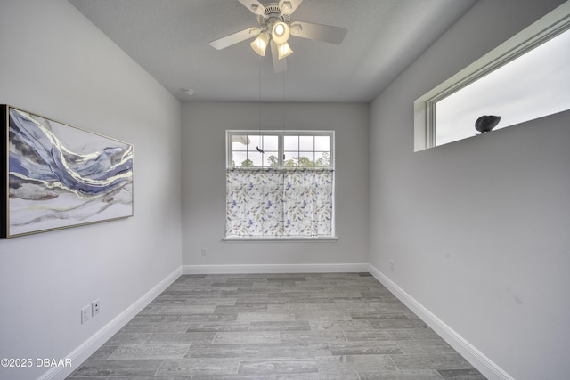 empty room with baseboards, ceiling fan, and wood finished floors