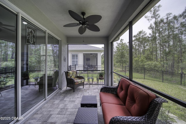 sunroom featuring ceiling fan and outdoor lounge area