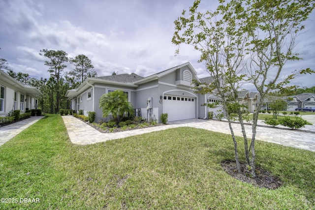 ranch-style home featuring an attached garage, a front lawn, stucco siding, and driveway