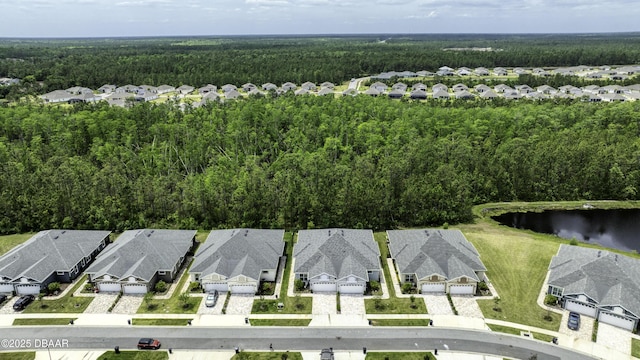 drone / aerial view featuring a forest view, a water view, and a residential view