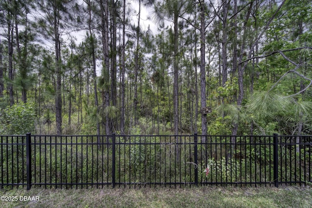 view of yard with a view of trees and fence