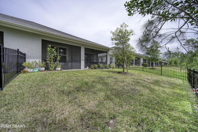 view of yard featuring a ceiling fan, a fenced backyard, and a sunroom