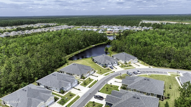 aerial view with a wooded view, a water view, and a residential view