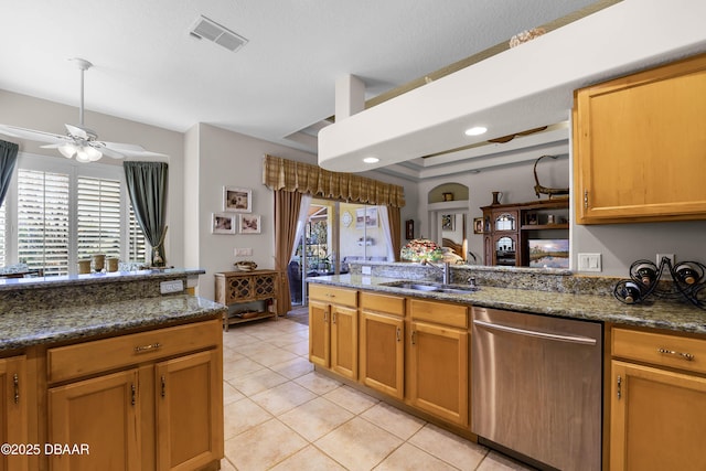 4 Arika At Lionspaw, Daytona Beach, FL 32124 - kitchen with stainless steel dishwasher, light tile patterned floors, a peninsula, a raised ceiling, and dark stone countertops