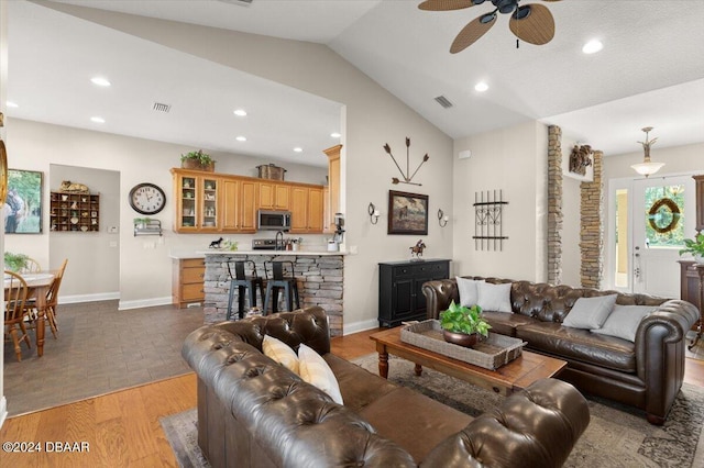 living room featuring ceiling fan, lofted ceiling, and hardwood / wood-style flooring