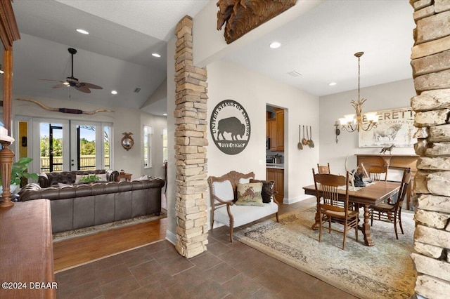 dining area with french doors, ceiling fan with notable chandelier, ornate columns, and lofted ceiling