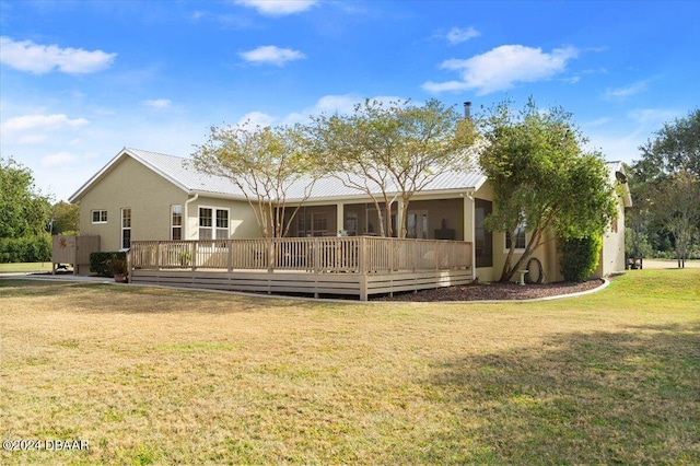 back of house with a lawn, a sunroom, and a deck