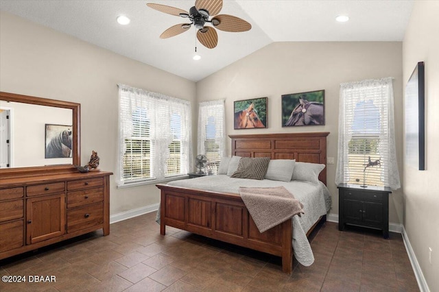 bedroom with dark tile patterned flooring, ceiling fan, multiple windows, and vaulted ceiling